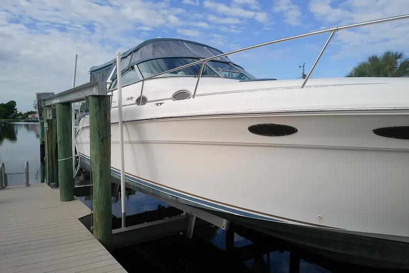 Slide: The Image of 1998 Sea Ray Sundancer 330 yacht docked, featuring sleek design and white exterior. - 6