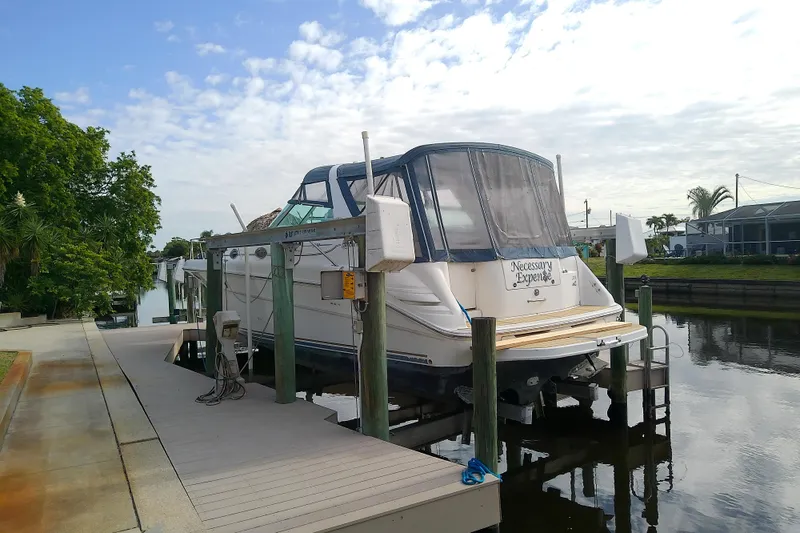 Slide: The Image of 1998 Sea Ray Sundancer 330 yacht docked on a lift by a canal. - 7