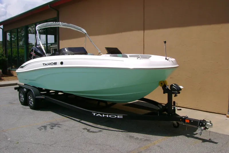 Slide: The Image of 2026 Tahoe T21 boat on trailer, parked outdoors, showcasing sleek design and mint green hull. - 1