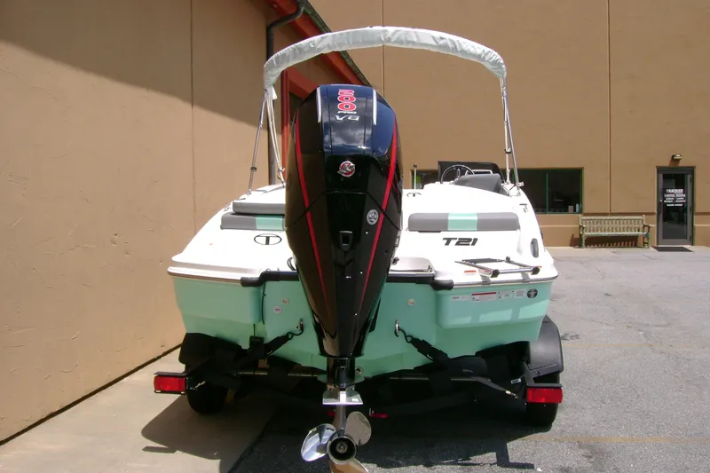 Slide: The Image of 2026 Tahoe T21 boat with outboard motor, parked outdoors near a beige building. - 4