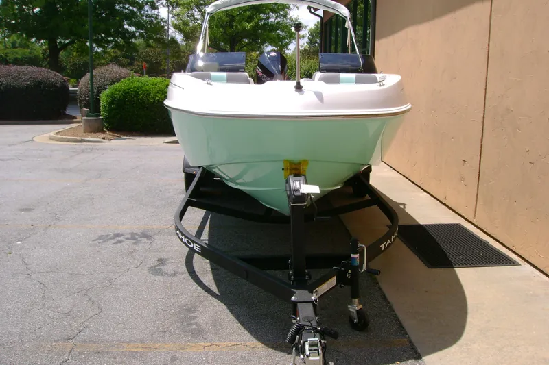 Slide: The Image of 2026 Tahoe T21 boat on trailer, parked outdoors near a building. - 3