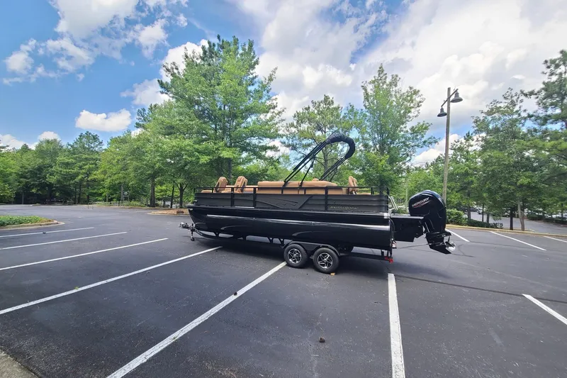 Slide: The Image of 2026 Ranger 223FC boat on trailer in parking lot, surrounded by trees and blue sky. - 3