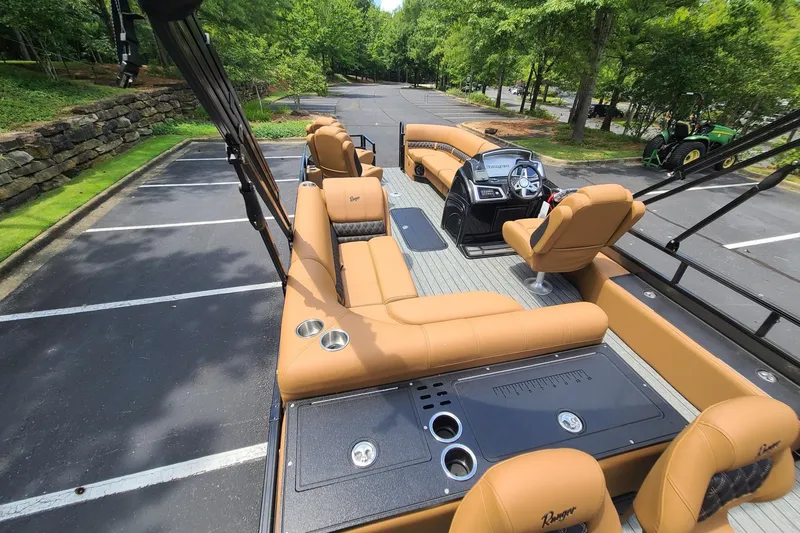 Slide: The Image of 2026 Ranger 223FC boat with tan seating, parked in a scenic lot. - 9