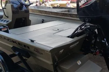 Slide: The Image of 2026 Tracker Grizzly 1860 CC boat with outboard motor, docked outdoors. - 3