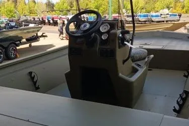 Slide: The Image of 2026 Tracker Grizzly 1860 CC boat interior with steering console and gauges. - 5