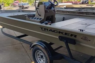 Slide: The Image of 2026 Tracker Grizzly 1860 CC boat on trailer, featuring steering console and spacious deck. - 6