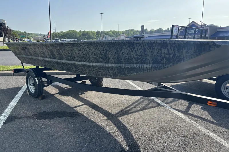 The Image of 2026 Tracker Grizzly 1648 Utility boat on trailer in parking lot. - 0