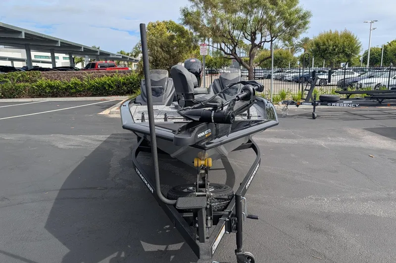 The Image of 2026 Tracker Pro Team 195 boat on trailer in parking lot, surrounded by greenery. - 0