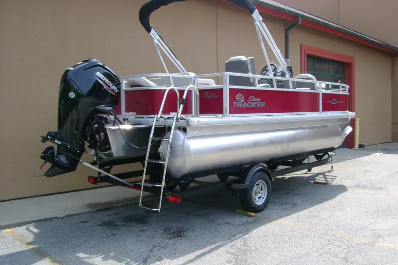 Slide: The Image of 2026 Sun Tracker Bass Buggy 18 DLX pontoon boat with Mercury outboard motor on trailer. - 4