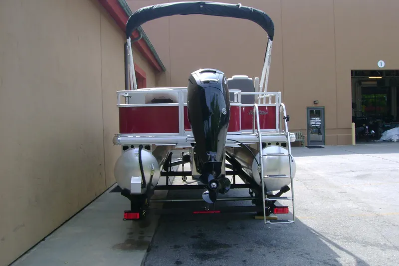 Slide: The Image of 2026 Sun Tracker Bass Buggy 18 DLX pontoon boat, rear view with motor and ladder. - 5