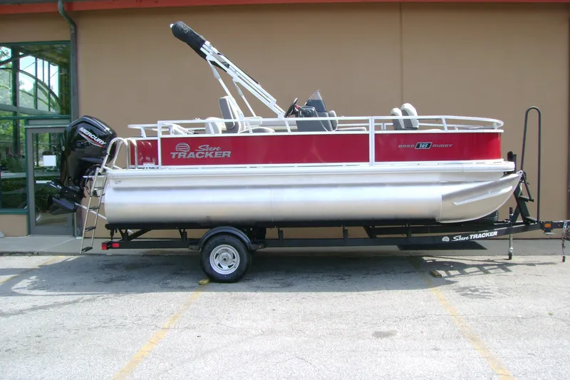 The Image of 2026 Sun Tracker Bass Buggy 18 DLX pontoon boat on trailer, parked outdoors. - 0