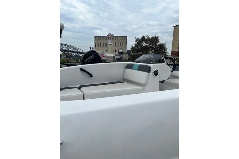 Slide: The Image of 2026 Tahoe T16 boat interior with seating, steering wheel, and Mercury engine in urban setting. - 1