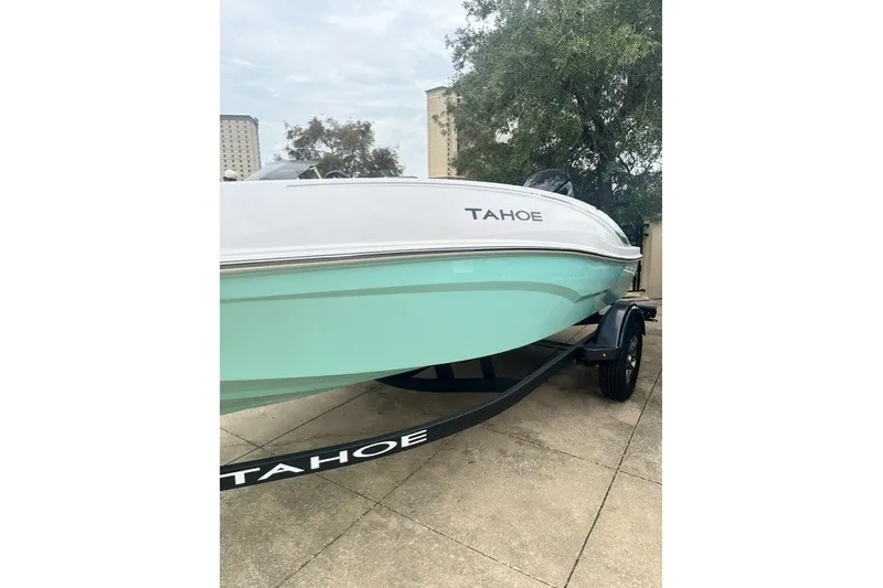 Slide: The Image of 2026 Tahoe T16 boat on trailer, mint green hull, parked outdoors. - 10