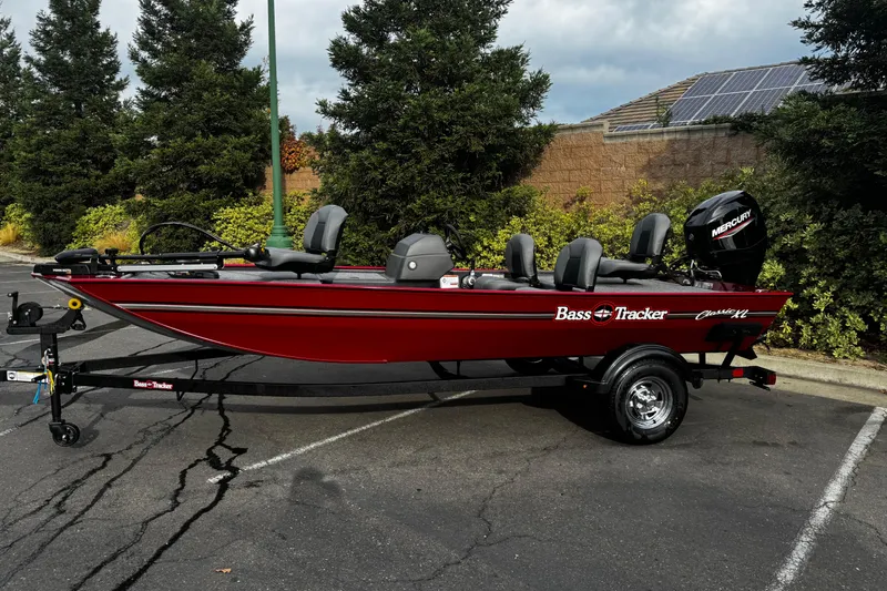 Slide: The Image of 2026 Tracker Bass Tracker Classic XL boat in parking lot, red with Mercury engine. - 2