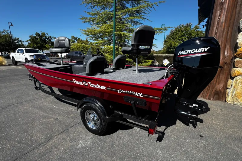 Slide: The Image of 2026 Tracker Bass Tracker Classic XL boat with Mercury engine, parked outdoors. - 3