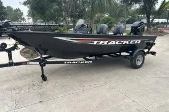 The Image of 2026 Tracker Super Guide V-16 SC boat on trailer, parked outdoors. - 0