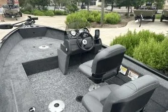 Slide: The Image of 2026 Tracker Super Guide V-16 SC boat interior with steering console and seating. - 3