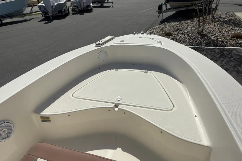 Slide: The Image of 2022 Pioneer 180 Sportfish boat interior with storage compartment, parked on asphalt. - 5