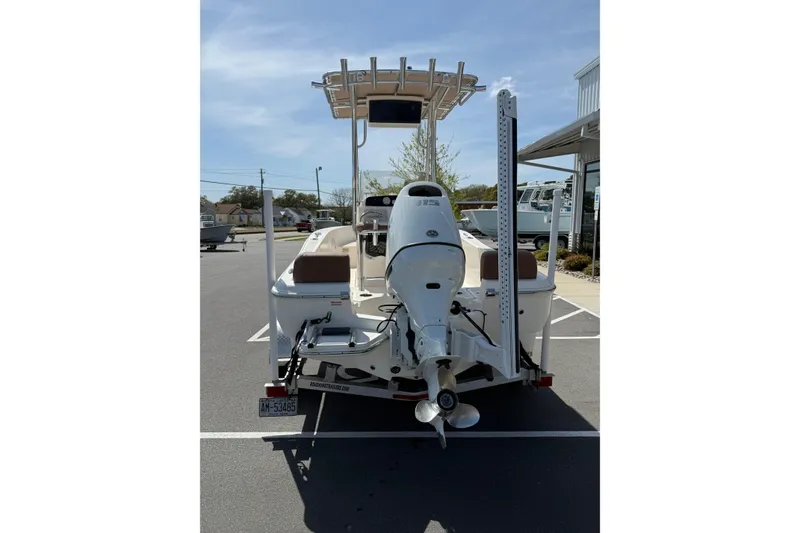 Slide: The Image of 2022 Pioneer 180 Sportfish boat, rear view with outboard motor, parked outdoors. - 8