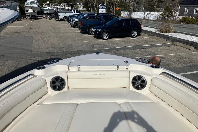 Slide: The Image of 2019 Grady-White Freedom 215 boat interior with seating and speakers in a parking lot. - 12