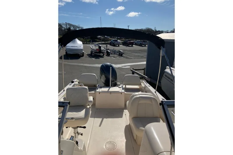 Slide: The Image of 2019 Grady-White Freedom 215 boat interior with seating and canopy in a parking area. - 6