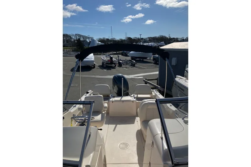 Slide: The Image of 2019 Grady-White Freedom 215 boat interior with seating and steering wheel, parked outdoors. - 9