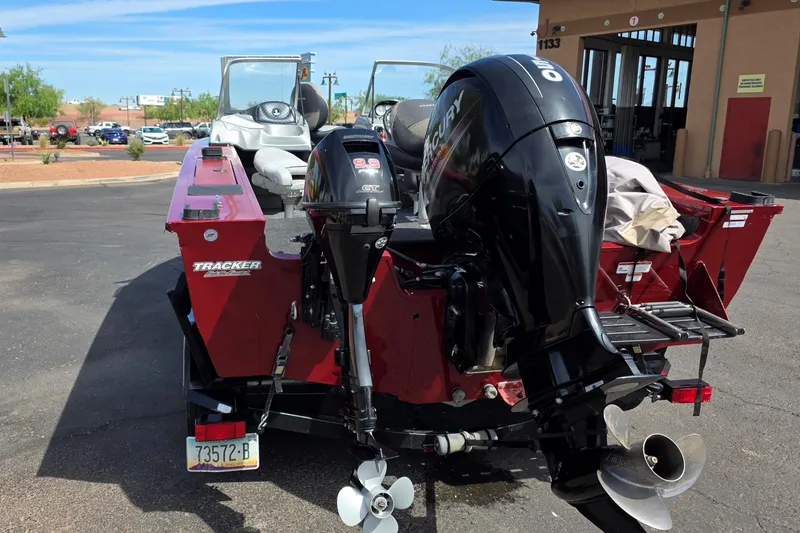 Slide: The Image of 2015 Tracker Targa V-18 Combo boat with dual outboard motors in a parking lot. - 4