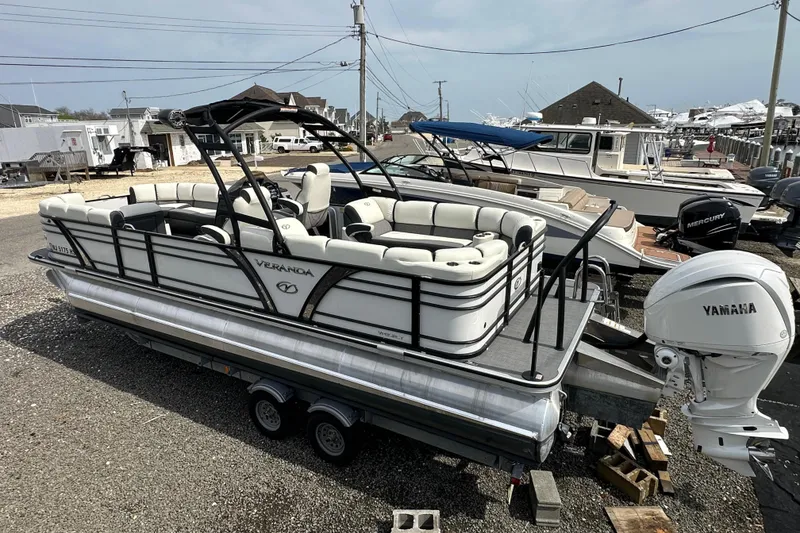 Slide: The Image of 2024 Veranda VP25RCT pontoon boat with Yamaha engine, parked at a marina. - 25