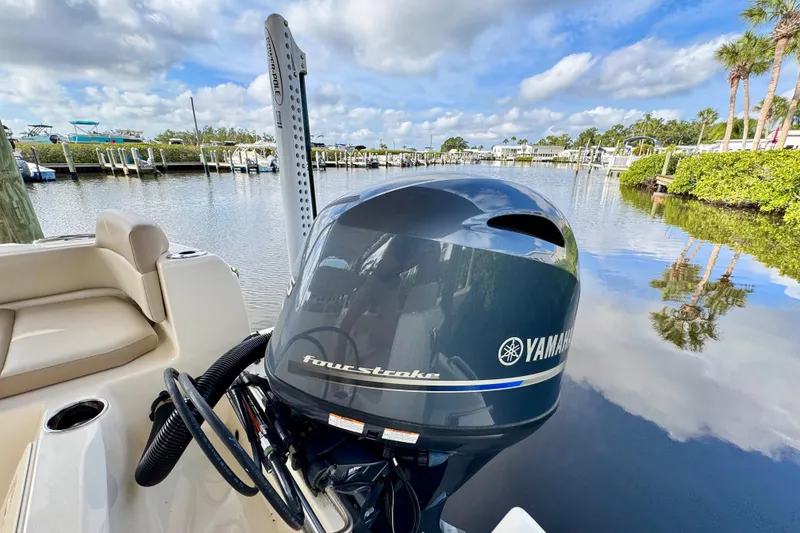 Slide: The Image of 2024 Scout 195 Sportfish with Yamaha engine, docked by a serene waterfront. - 17