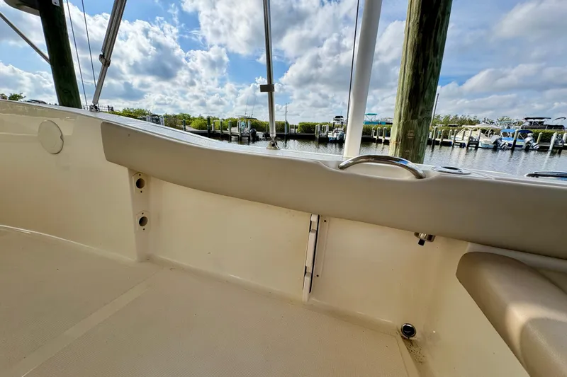 Slide: The Image of 2024 Scout 195 Sportfish boat interior with dockside view under a cloudy sky. - 19