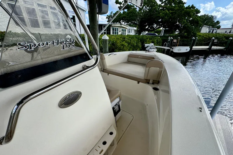 Slide: The Image of 2024 Scout 195 Sportfish boat docked, showcasing sleek design and comfortable seating. - 32
