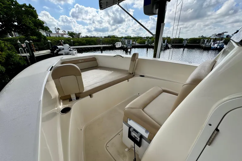 Slide: The Image of 2024 Scout 195 Sportfish boat interior with seating, docked by a scenic waterfront. - 33