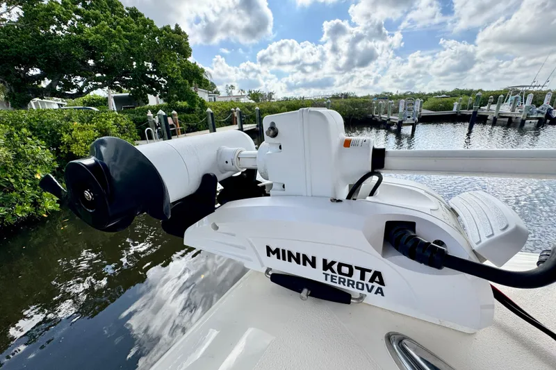 Slide: The Image of 2024 Scout 195 Sportfish with Minn Kota Terrova trolling motor by a scenic waterway. - 38