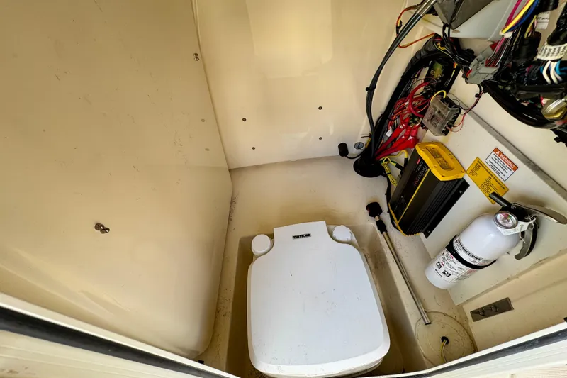 Slide: The Image of 2024 Scout 195 Sportfish boat interior with toilet, wiring, and fire extinguisher. - 44