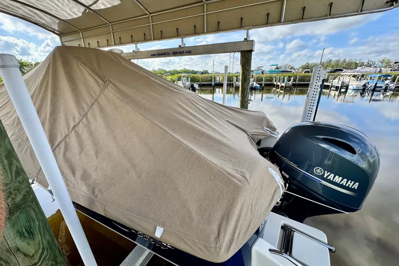 Slide: The Image of 2024 Scout 195 Sportfish boat covered, docked with Yamaha outboard motor. - 46
