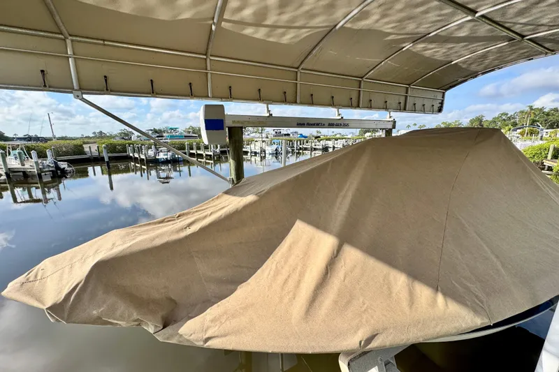 Slide: The Image of 2024 Scout 195 Sportfish boat covered at a marina dock under a canopy. - 47