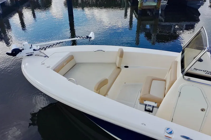 Slide: The Image of 2024 Scout 195 Sportfish boat with seating, docked on calm water. - 5