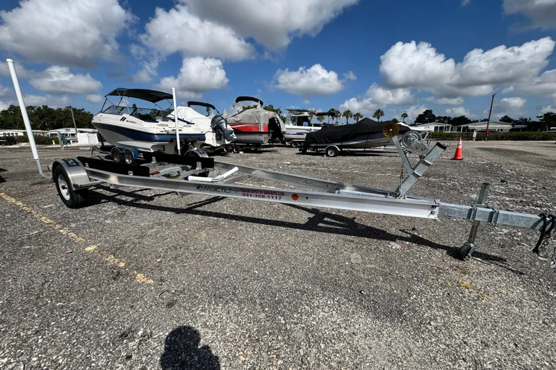 Slide: The Image of 2024 Scout 195 Sportfish boat on trailer under a clear blue sky. - 50