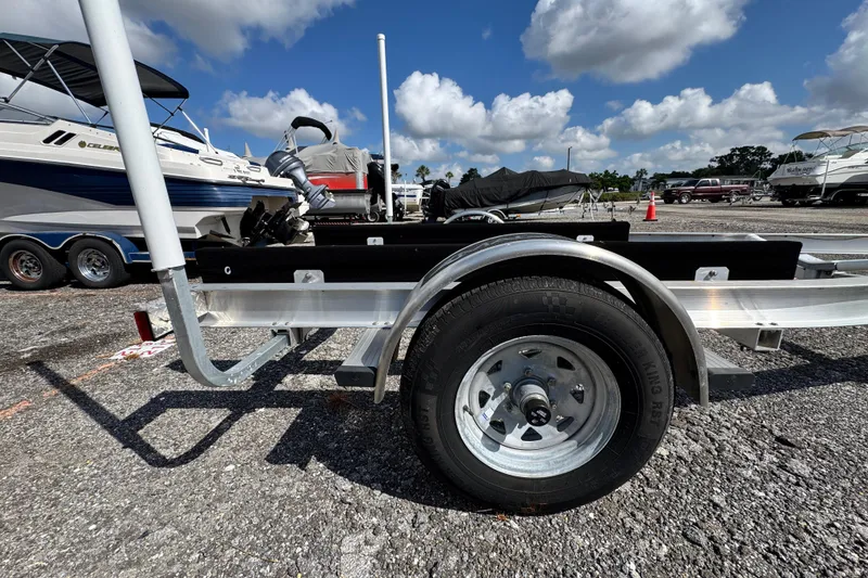 Slide: The Image of Trailer for 2024 Scout 195 Sportfish boat in a marina parking lot. - 52