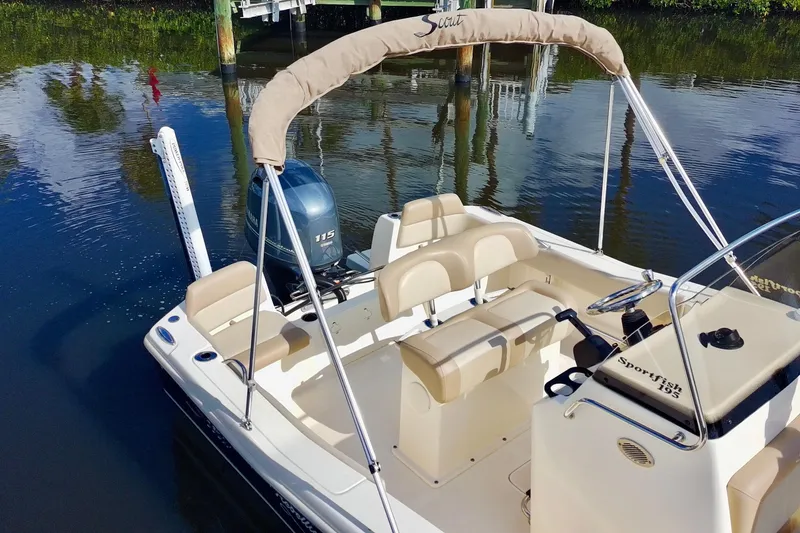 Slide: The Image of 2024 Scout 195 Sportfish boat with Yamaha 115 engine, docked on calm water. - 7