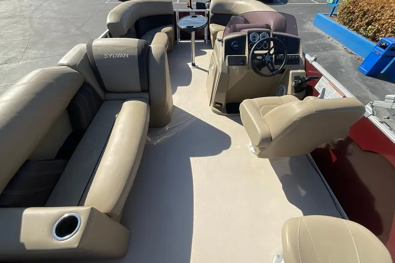 Slide: The Image of 2021 Sylvan Mirage Fish 820 Party Fish boat interior with beige seating and steering console. - 13