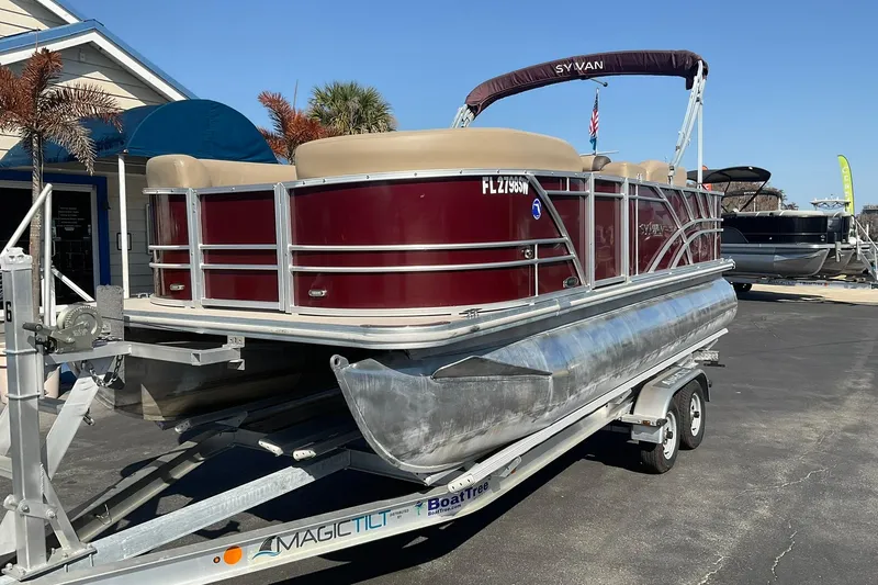 Slide: The Image of 2021 Sylvan Mirage Fish 820 Party Fish pontoon boat on trailer, parked outdoors. - 2