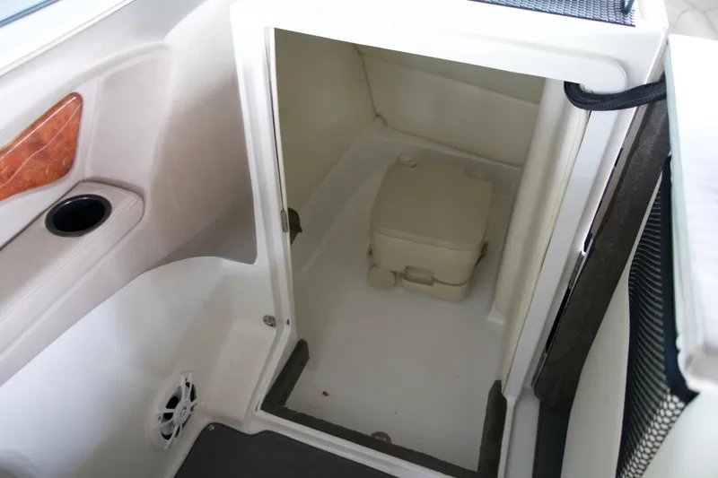 Slide: The Image of Interior of a 2005 Cobalt 262 boat featuring a compact portable toilet. - 11