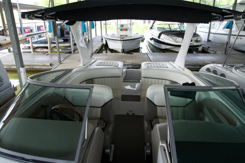 Slide: The Image of 2005 Cobalt 262 boat interior at marina dock, featuring white seating and canopy. - 13