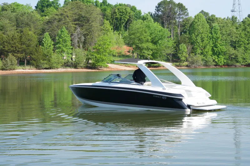 Slide: The Image of 2005 Cobalt 262 boat cruising on a serene lake surrounded by lush greenery. - 4