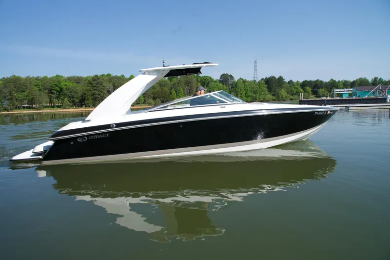 Slide: The Image of 2005 Cobalt 262 boat on calm lake with lush green shoreline. - 5