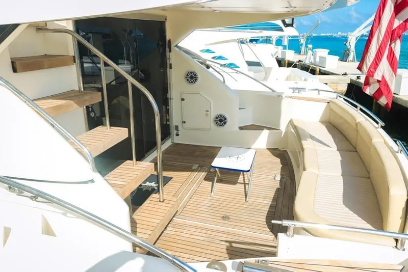 Slide: The Image of Luxurious 2006 Fairline 50 yacht deck with seating and table, docked by the sea. - 10