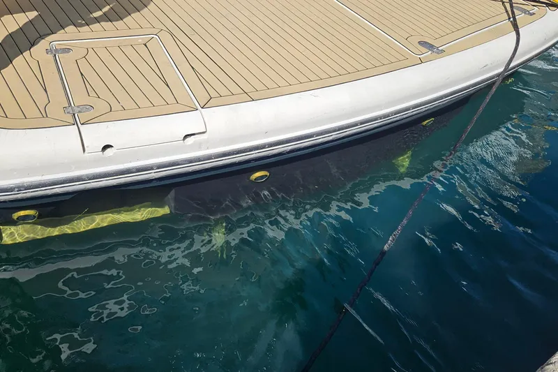 Slide: The Image of Fairline 50 yacht (2006) docked, showing deck and hull above clear blue water. - 12