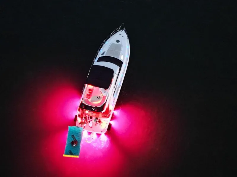 Slide: The Image of Aerial view of 2006 Fairline 50 yacht with vibrant pink underwater lights. - 19