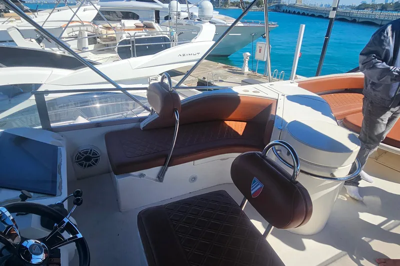 Slide: The Image of Luxurious 2006 Fairline 50 yacht interior with leather seating and steering wheel, docked at marina. - 4